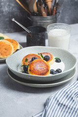 Cottage cheese pancakes with cream sauce and blueberries. syrniki 