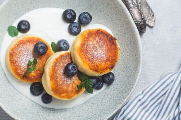 Cottage cheese pancakes with cream sauce and blueberries. syrniki 