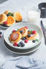 Cottage cheese pancakes with creamy sauce, raspberries and blueberries