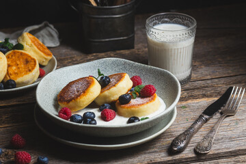 Cottage cheese pancakes with creamy sauce, raspberries and blueberries
