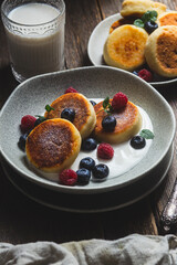 Cottage cheese pancakes with creamy sauce, raspberries and blueberries