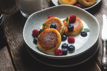 Cottage cheese pancakes with creamy sauce, raspberries and blueberries