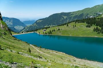 Fototapeta na wymiar view of beautiful Bannalpsee a reservoir surrounded by mountains in the Swiss alps, Walenpfad