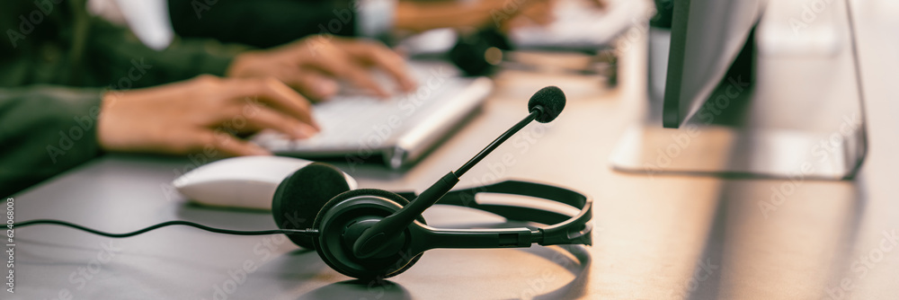 Aufkleber panorama focus headset on call center workspace desk with blur background of operator team or telesa