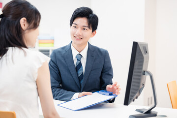 窓口で顧客の要望を聞く男性スタッフ