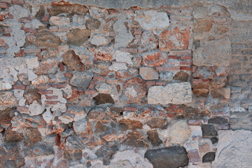 Empty aged weathered stonewall background texture. Old worn peeled surface for backdrop. Copy space