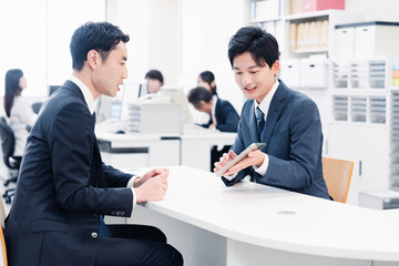 窓口でタブレットを用いて案内をする男性スタッフ