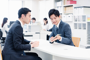 窓口でタブレットを用いて案内をする男性スタッフ