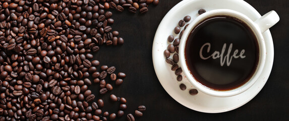 Coffee Americano. Top view of a cup of coffee on the background of roasted coffee beans. Lettering Coffee in a white cup. Banner
