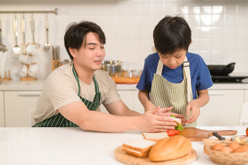 Happy Young Asian father and son eating healthy food in kitchen at home