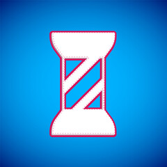 White Sewing thread on spool icon isolated on blue background. Yarn spool. Thread bobbin. Vector