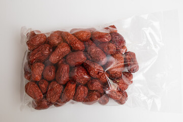 Dried jujube seeds which are brown overlay on a white background. Jujube seeds is an ingredient in desserts, soups and drinks. Close-up 