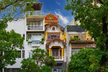 Old Apartment house block in Hanoi Old Quarters Vietnam narrow tall houses with plants on exterior of the building colourfully decorated 