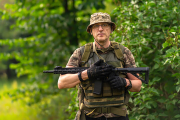 Portrait of a man with a weapon on a background of vegetation