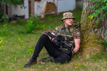 Fototapeta premium A man in military uniform with a weapon, looks around