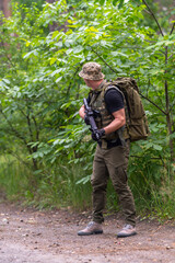 Fototapeta premium A man with a rifle looks along the road