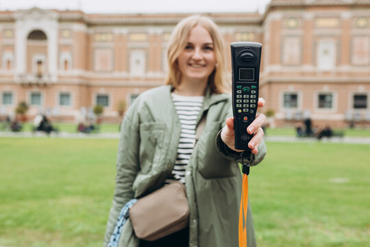 Young blonde woman listening to audio guide at the Vatican Museums in Rome, Italy