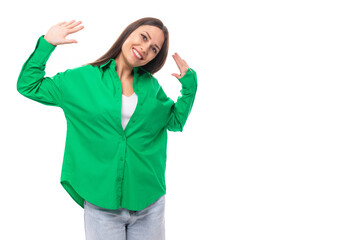 bright cheerful young brown-haired female model with brown eyes in a green shirt posing on a white background with copy space