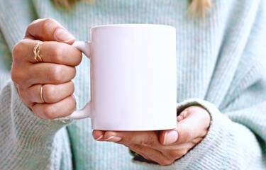 Girl is holding white mug in hands. Blank 11 oz ceramic cup