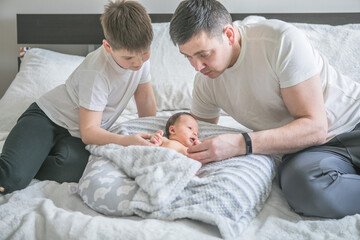 Portrait of father and his four son holding his newborn baby