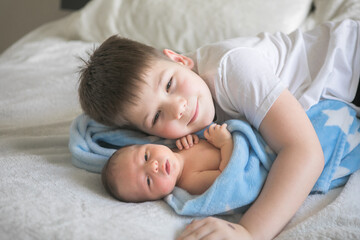 Fototapeta na wymiar happy little kid boy with his newborn baby brother
