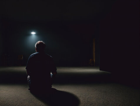 暗い部屋に一人ぼっちで膝を抱える男性の後ろ姿3: AI生成画像  Back view of a man holding his knees, alone in a dark room. generative AI