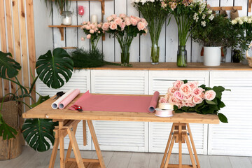 Florist's workplace in flower shop with paper for wrapping the bouquet of roses.