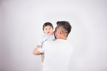 Beautiful photo of dad holding baby on light photo studio background. Family and baby concept.