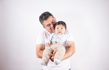 Beautiful photo of dad holding baby on light photo studio background. Family and baby concept.