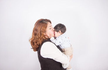 Beautiful photo of loving mom with baby on light photo studio background. Family and baby concept.