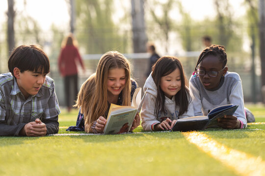 Lovely pupils on reading on the grass
