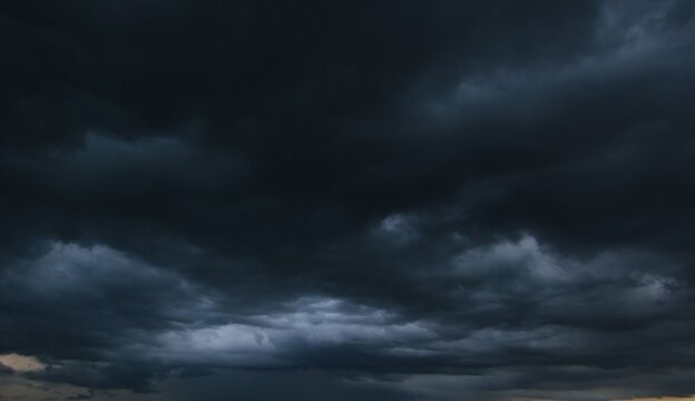 The dark sky with heavy clouds converging and a violent storm before the rain.Bad or moody weather sky and environment. carbon dioxide emissions, greenhouse effect, global warming, climate change