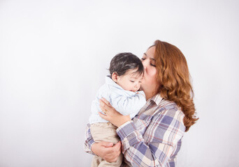 Beautiful photo of mom holding baby on light background in photo studio. Family and baby concept.
