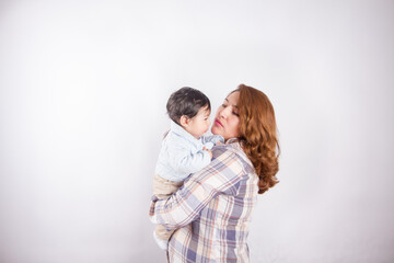 Beautiful photo of mom holding baby on light background in photo studio. Family and baby concept.