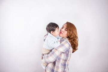 Beautiful photo of mom holding baby on light background in photo studio. Family and baby concept.