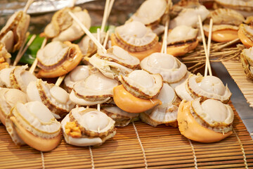 Grilled scallops on skewers in a traditional market