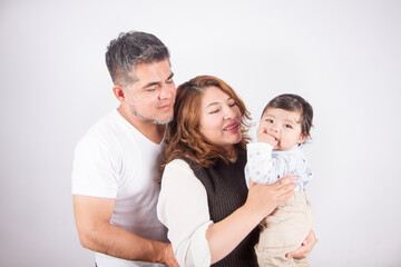 Beautiful photo of Dad and mom holding baby on light photo studio background. Family and baby concept.