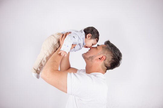 Beautiful photo of Dad holding his baby on light photo studio background. Family and baby concept.