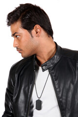 A young Indian guy in a black leather jacket staring at someone.