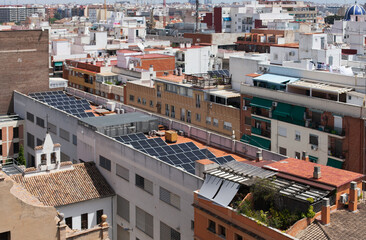 Fototapeta premium Solar panels installed on the roof of apartment building. Renewable source of energy in modern city.