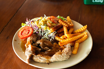 Delicious steak paired with French fries and vegetable salad in one dish.