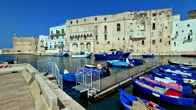 Traditional Italy - picturesque white town Monopoli with colorful fishinng boats. Puglia region popular destination for summer holidays
