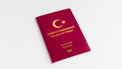 A close-up snapshot featuring a Turkish passport positioned against a clean white backdrop