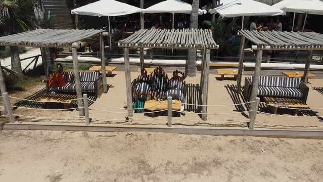 Toma aerea en 4k de unos amigos tomando algo en la terraza de un chiringuito