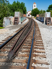 Fototapeta na wymiar Railroad tracks lead across a bridge to a train station