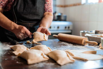 Flavors of Heritage: Latin Elderly Woman Preparing Chilean Baked Beef Empanadas in the Warmth of...