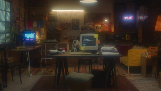 Dolly in shot of 90s office in garage interior with computers on desks and posters on walls
