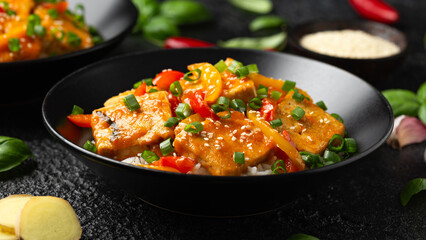 Homemade Stir Fry Tofu with Vegetables and Rice in black bowl.