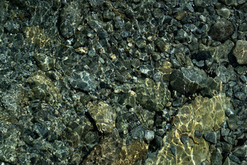 Textured background of stones in the riverbed