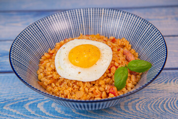 RECIPE FOR BLE WITH BACON, TOMATO AND SHALLOTS, SERVED WITH FRIED EGG. High quality photo
